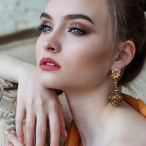 Stunning close-up portrait of a woman with elegant makeup and jewelry, epitomizing modern fashion and beauty.